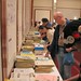 A really long table with huge piles of fanzines