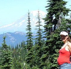 me and my 36 inch-round belly standing on a rock with mt. rainier in the background